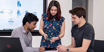 Three engineers collaborating round a desk